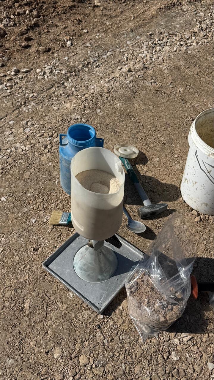 Sand cone set up on the layer to measure density